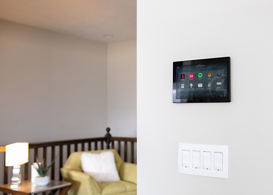 A Control4 touch panel installed in a living room wall.